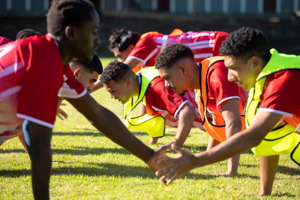 Jugadores Masculinos Multirraciales Uniformes Rojos Practicando Cinco Flexiones Seguidas Campo —  Fotos de Stock