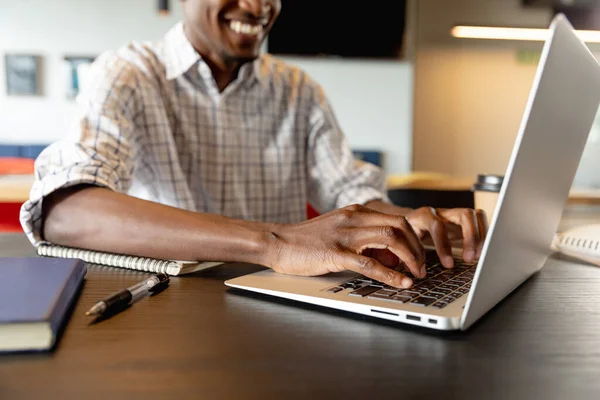 Środek Uśmiechniętego Afrykańskiego Młodego Biznesmena Używającego Laptopa Biurze Kreatywnym Niezmieniony — Zdjęcie stockowe