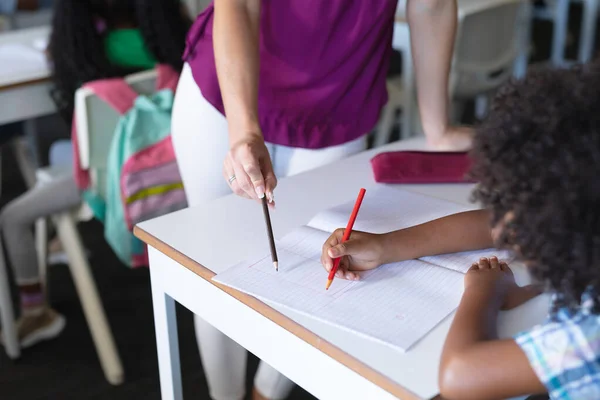 白人の若い女性教師がアフリカ系アメリカ人の小学生に教えている 変化のない教育教育子供時代職業学校の概念 — ストック写真