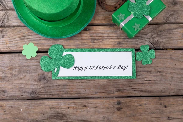 Top view of st patrick\'s day decorations with happy st patrick\'s day text banner on wooden surface. st patrick\'s day celebration concept