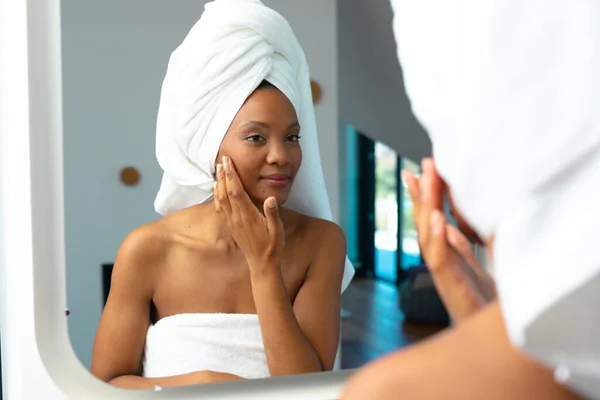 非洲裔美国女青年在家里照镜子的时候摸着她的脸颊 未经改动的温泉 身体护理和幸福概念 — 图库照片