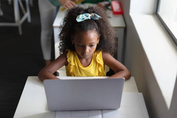 教室の机の上でノートパソコンを使ってアフリカ系アメリカ人の小学生の高角度ビュー 変化のない教育子供時代学習教育無線技術学校の概念 — ストック写真