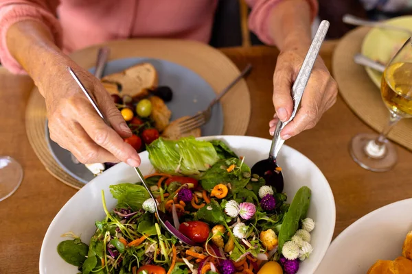 ダイニングテーブルにスプーンで野菜サラダを取る白人シニア女性の作物の手 老人ホーム 新鮮です 変更されていません サポート 支援生活や退職の概念 — ストック写真