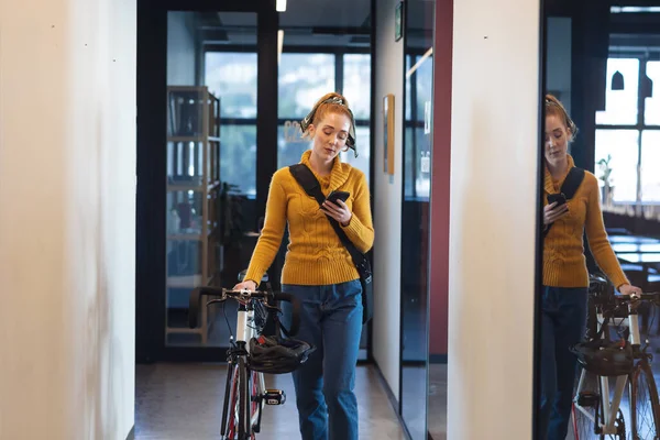 Kaukasiska Affärskvinna Med Cykel Med Mobiltelefon När Går Korridoren Kontoret — Stockfoto