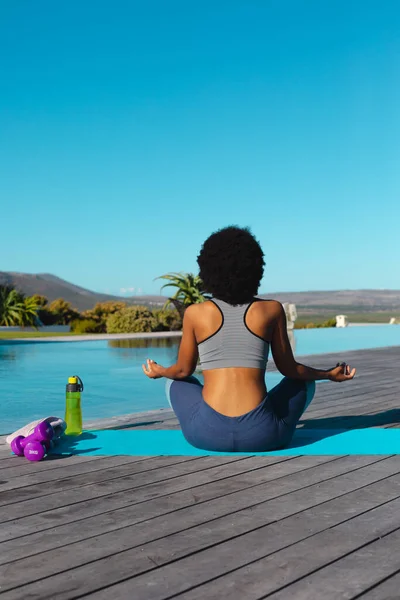 Young Afro African American Woman Meditating Poolside Copy Space Unaltered  Stock Photo by ©Wavebreakmedia 654899006