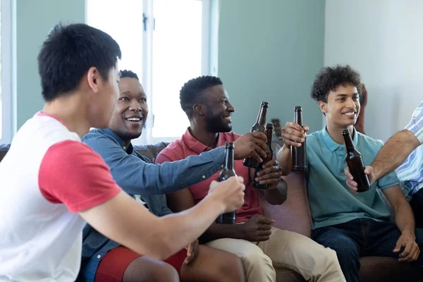 快乐的多种族男性朋友一边烘焙啤酒瓶 一边在家里消磨时光 复制空间 娱乐和周末活动 — 图库照片