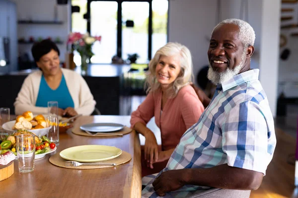 坐在疗养院的多种族老年朋友的画像 餐桌上有盘子和食物 辅助生活和退休概念 — 图库照片
