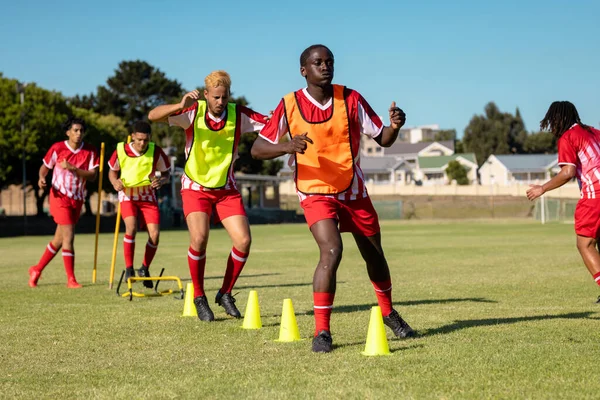 Multiraciale Mannelijke Spelers Rode Truien Rennen Rond Gele Kegels Speelplaats — Stockfoto