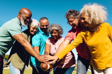 Happy senior multiracial friends playing rugby against clear sky in yard at nursing home in summer. Copy space, unaltered, sport, togetherness, enjoyment, support, assisted living and retirement. clipart