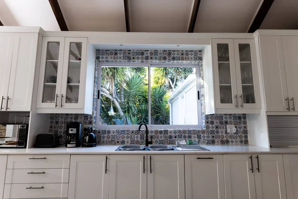 Modern Mutfakta Lavabonun Pencerenin Kapalı Beyaz Dolapların Düşük Açılı Görüntüsü — Stok fotoğraf