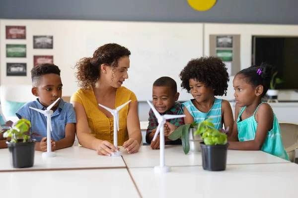 Jovem Professora Caucasiana Mostrando Modelo Moinho Vento Para Alunos Afro — Fotografia de Stock