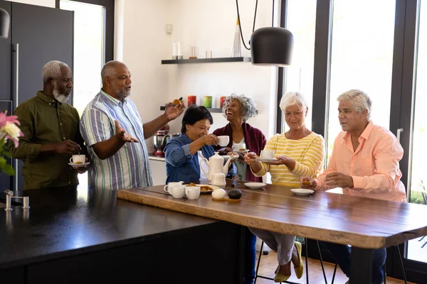 Cheerful Multiracial Seniors Talking Enjoying Coffee Cookies Wooden Table Nursing — Stock Photo, Image