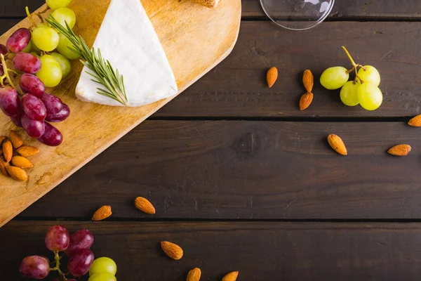 高角度的奶酪和葡萄与杏仁在木制桌子上 复制空间 水果和奶制品 — 图库照片