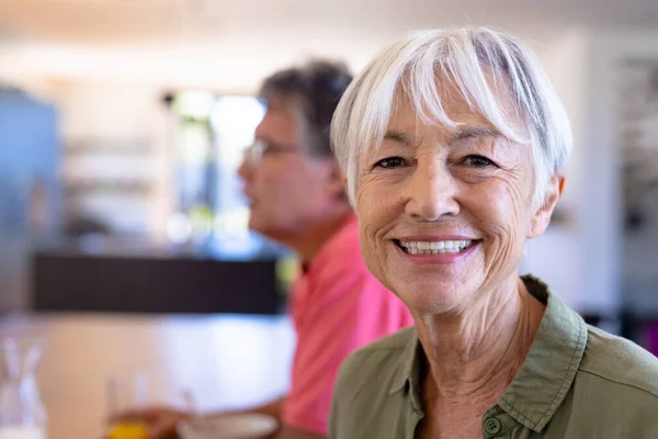 老人ホームで白人男性と座っている笑顔のアジア系シニア女性のクローズアップポートレート 変更されず 支援された生活と退職の概念 — ストック写真