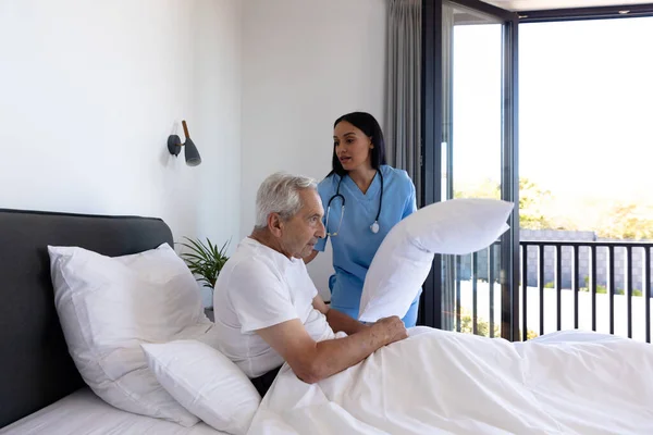 Biracial Female Physiotherapist Adjusting Pillows Caucasian Senior Man Lying Bed — Stock Photo, Image