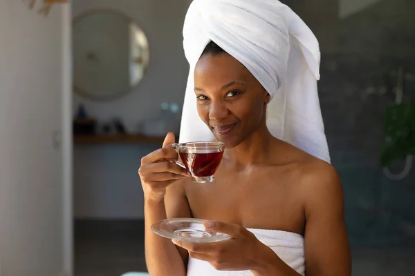 非洲裔美国妇女穿着浴衣在家里拿着茶杯的画像 自我照顾 卫生和放松的概念 — 图库照片