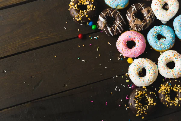 Diretamente Acima Visão Vários Donuts Frescos Com Aspersores Balas Mesa — Fotografia de Stock