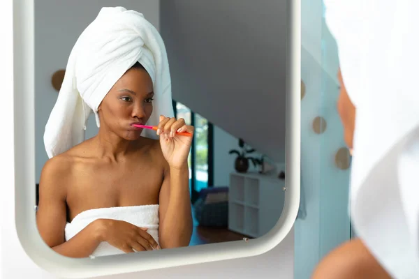 Αφροαμερικανή Νεαρή Γυναίκα Βουρτσίζει Δόντια Της Ενώ Κοιτάζει Στον Καθρέφτη — Φωτογραφία Αρχείου