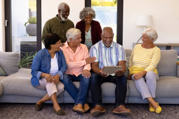Wesoły Wielorasowy Starsi Przyjaciele Patrząc Seniora Pomocą Tabletu Cyfrowego Podczas — Zdjęcie stockowe