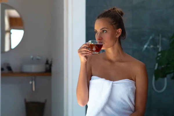 身穿浴衣的白人年轻女子在家里喝茶 自我照顾 卫生和放松的概念 — 图库照片