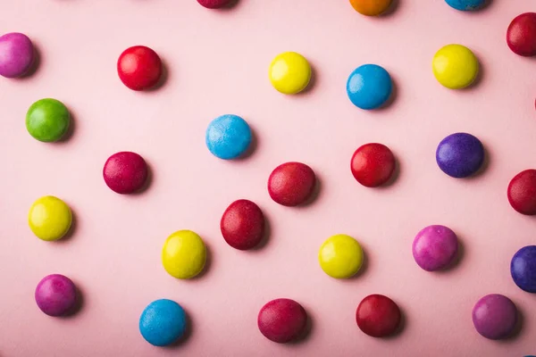 正上方是分散在粉红背景上的多色巧克力糖果 不变的 不健康的饮食和甜食概念 — 图库照片