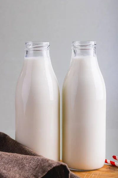 Närbild Mjölkflaskor Mot Grå Bakgrund Med Kopieringsutrymme Oförändrat Mat Dryck — Stockfoto