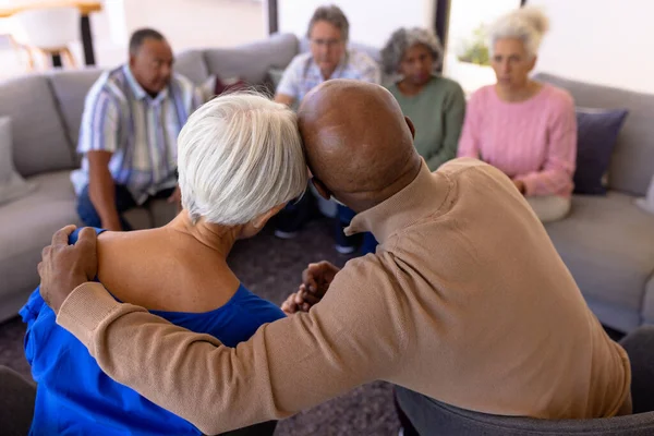 在疗养院的集体治疗课程中 多种族老年男性拥抱女性的后视镜 辅助生活 — 图库照片