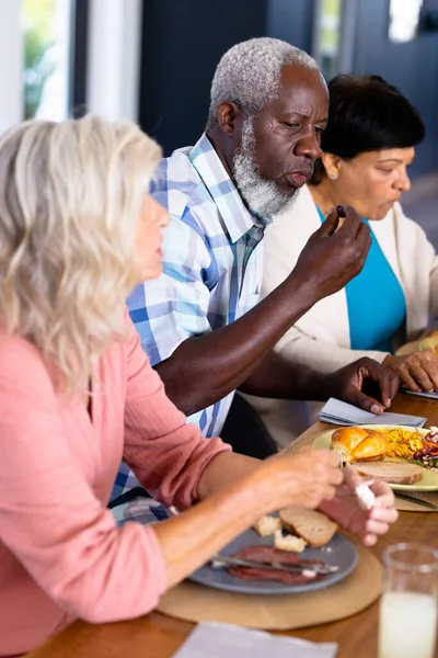 非裔美国老年男子在饭桌上与多种族的女性朋友共进午餐 疗养院 辅助生活和退休概念 — 图库照片