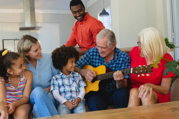 Feliz Familia Multirracial Multigeneración Mirando Hombre Mayor Tocando Guitarra Mientras —  Fotos de Stock