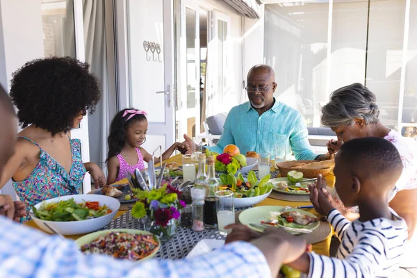 多种族多代家庭手牵着手 在饭前餐桌前说着优雅的话 饮食和家庭 — 图库照片