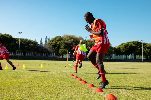 Multiraciale Mannelijke Spelers Rennen Springen Grasland Speeltuin Tegen Heldere Hemel — Stockfoto