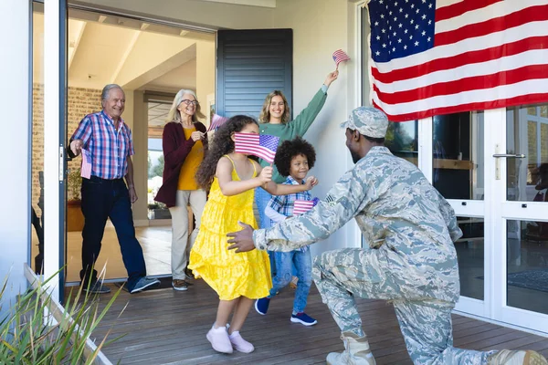 Багаторасова Схвильована Багатоповерхова Родина Прапором Америки Вітає Солдата Армії Будинку — стокове фото