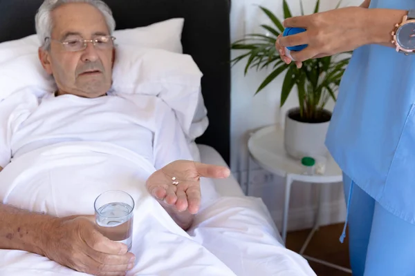 Midsection Fisioterapeuta Biracial Feminino Dando Medicamentos Para Homem Idoso Caucasiano — Fotografia de Stock