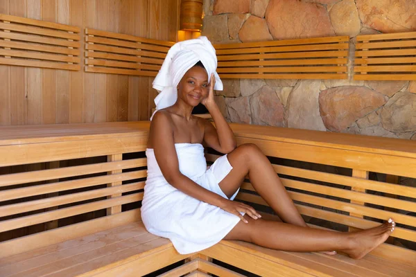 Πορτρέτο Της Νεαρής Αφροαμερικανής Γυναίκας Τυλιγμένο Πετσέτες Κάθεται Στη Σάουνα — Φωτογραφία Αρχείου