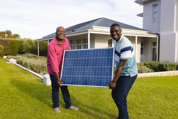 Afrikanisch Lächelnder Älterer Mann Und Sohn Tragen Solarzellen Während Sie — Stockfoto