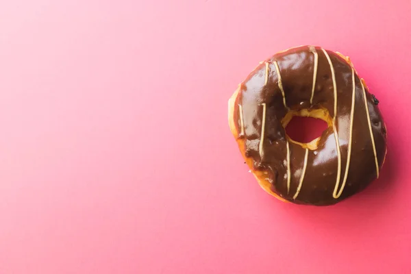 ピンクを背景にしたコピースペースによるフレッシュチョコレートドーナツの俯瞰図 変化のない不健康な食生活と甘い食の概念 — ストック写真