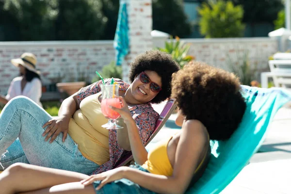 Biracial Female Friends Afro Hair Toasting Cocktails While Lying Deckchairs — Stock Photo, Image