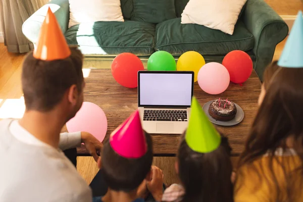 白人の家族は 誕生日を祝う家で時間を過ごし パーティー帽子をかぶって ソファに座って ラップトップコンピュータを使用しています Covid 19隔離での高品質な時間と誕生日お祝い — ストック写真