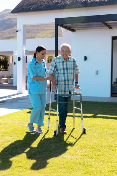 Biracial Γυναίκα Γιατρός Βοηθώντας Χαμογελαστός Καυκάσιος Ηλικιωμένος Άνδρας Στο Περπάτημα — Φωτογραφία Αρχείου
