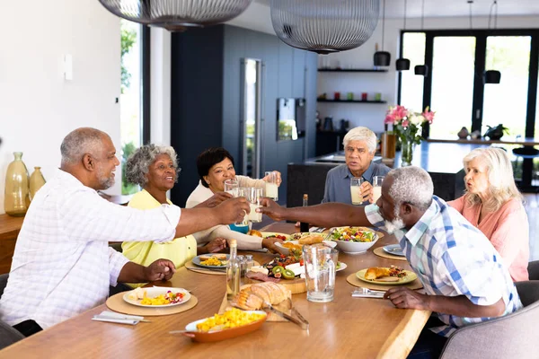 Fröhlich Gemischte Männliche Und Weibliche Senioren Stoßen Beim Mittagessen Esstisch — Stockfoto