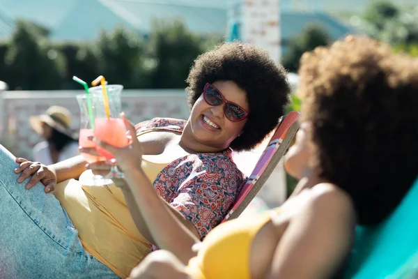 Happy Biracial Millennial Female Friends Afro Hair Toasting Drinks While — Stock Photo, Image
