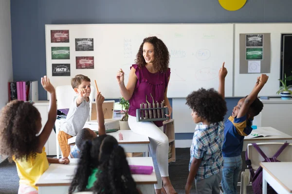 多人種の小学生が手を挙げ 女性の白人教師が授業で植物を見せている 変化のない教育子供時代教育学習科学学校の概念 — ストック写真