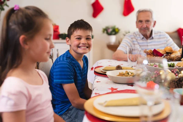 一个白人男孩面带微笑地看着相机 坐在餐桌旁与家人共进晚餐的画像 高质量的生活方式家庭团聚时间 — 图库照片