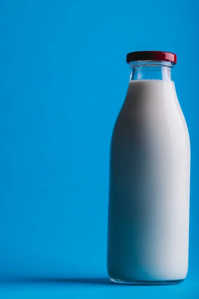 コピースペースと青の背景にミルクボトルのクローズアップ 変更されていない 食べ物 飲み物 スタジオで撮影された健康的な食品コンセプト — ストック写真