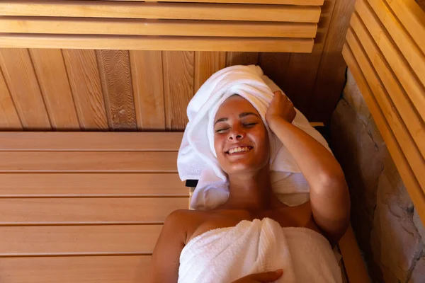 穿着浴衣的白人年轻女子在桑拿放松 健康和放松的概念 — 图库照片