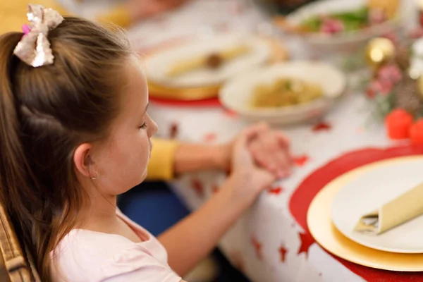 白人の少女はテーブルに座り 夕食前に目を閉じて祈ります 質の高いライフスタイルの家族で — ストック写真