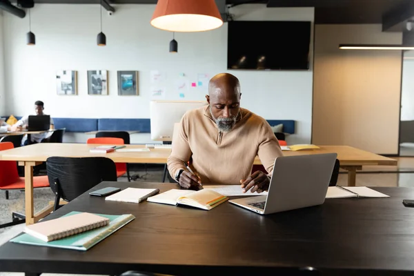 Yaratıcı Ofiste Dizüstü Bilgisayarla Otururken Günlüğe Yazan Afro Amerikalı Olgun — Stok fotoğraf