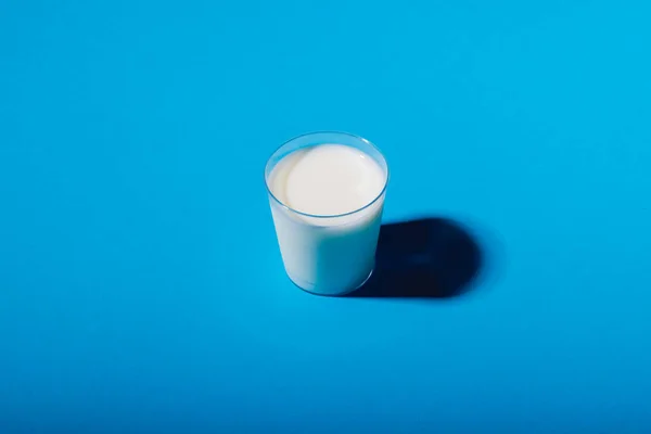 青い背景にミルクガラスの高い角度ビュー コピースペース 変更されていない 食べ物 飲み物 スタジオで撮影された健康的な食品コンセプト — ストック写真