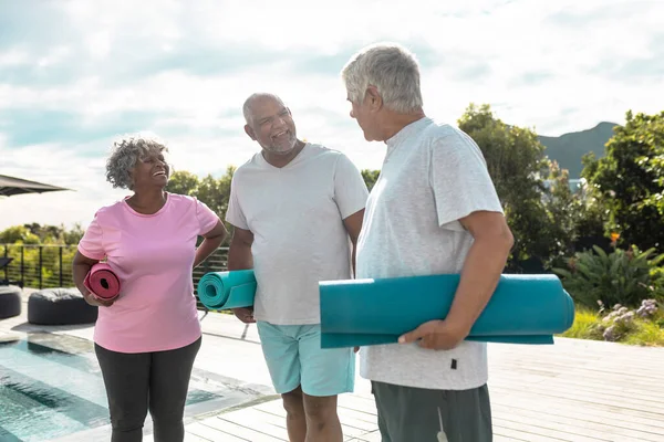 庭の空に向かって立っている間 運動マットと幸せな多人種のシニアの友人 老人ホーム 変更なし 生活支援 フィットネスコンセプト — ストック写真