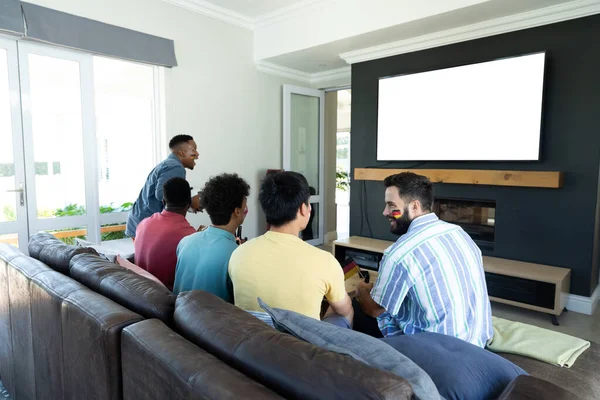 Mužské Multiraciální Přátelé Sledování Televize Při Relaxaci Pohovce Obývacím Pokoji — Stock fotografie